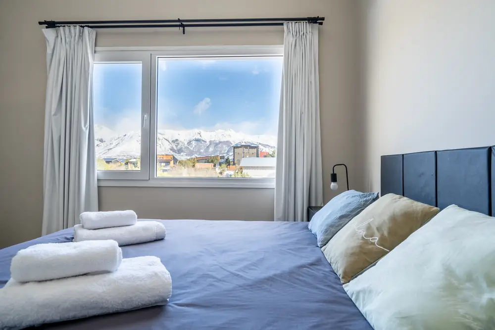 Dormitorio principal con cama king y vista a los cerros